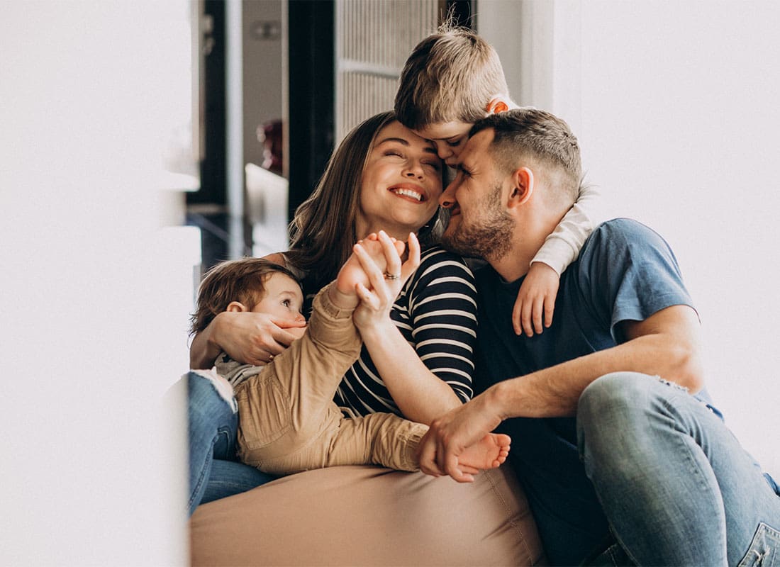 Insurance Solutions - Portrait of a Happy Family with Two Young Children Having Fun Spending Time Together While Sitting in the Living Room.jpg